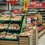 Colorful produce aisle in a supermarket showcasing fresh apples with discount signage.